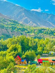 a group of houses with mountains in the background at Fish Lake Park Guest House in Chitral +10 photos
