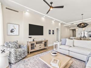 a living room with a couch and a tv at Adagio #401B in Santa Rosa Beach