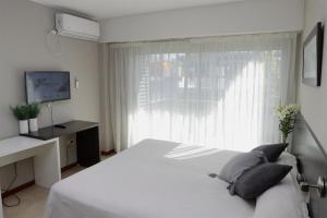 a bedroom with a white bed and a window at Rosario Temporal in Rosario