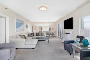 a living room with couches and a tv at Emerald Dolphin #1610 in Pensacola Beach