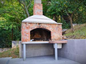 a brick oven sitting on top of a wall at Kuća za odmor Đogić - bazen & jacuzzi in Ilidža