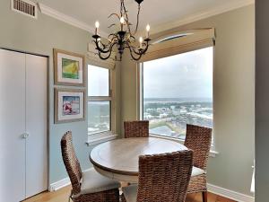 a dining room with a table and chairs and a window at Beach Colony East #15A in Perdido Key