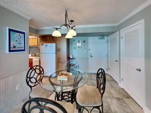 a dining room with a glass table and chairs at Sabine Yacht & Racquet #5F in Pensacola Beach