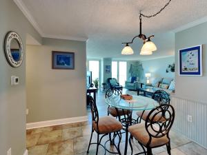 a dining room and living room with a table and chairs at Sabine Yacht & Racquet #5F in Pensacola Beach