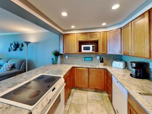 a kitchen with wooden cabinets and a stove top oven at Sabine Yacht & Racquet #5F in Pensacola Beach +20 photos