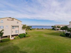 a large yard with a house and the ocean at Santa Rosa Dunes #1022 in Pensacola Beach