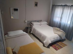 a bedroom with two beds and a mirror in it at NGEBE Lodge jozini in Jozini