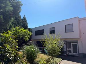 a white building with trees in front of it at Village Apartment Rheinbreitbach in Rheinbreitbach +3 photos
