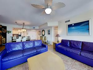 a living room with a blue couch and a table at Portofino Island Resort #2-1608 in Pensacola Beach