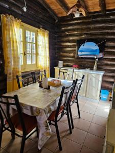 a dining room with a table and chairs and a kitchen at Cabañas San Francisco in Potrerillos