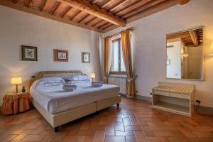 a bedroom with a large bed and a mirror at Relais Cloister Pienza in Pienza