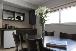 a vase of flowers on a table in a kitchen at Rosario Temporal in Rosario +12 photos