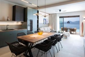 a kitchen and dining room with a wooden table and chairs at Zoe Sea View Villas in Paleros