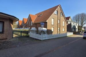 a large brick house with a white fence at Haus Rüther in Borkum