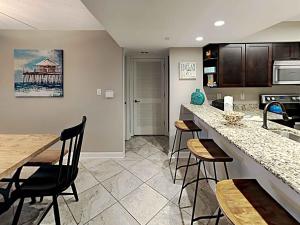 a kitchen with a counter and chairs in a room at Regency Towers #205 West in Pensacola Beach