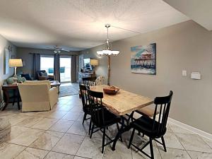 a dining room and living room with a table and chairs at Regency Towers #205 West in Pensacola Beach