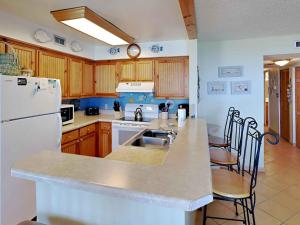 a kitchen with a white refrigerator and a sink at Santa Rosa Dunes #952 in Pensacola Beach