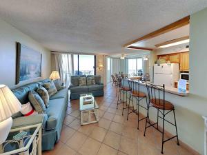 a living room with a blue couch and a kitchen at Santa Rosa Dunes #952 in Pensacola Beach