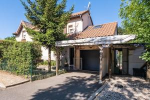 a white house with an awning in front of a driveway at La villa d'alyxia in La Bastide-Puylaurent