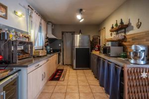 a kitchen with a refrigerator and a counter top at La villa d'alyxia in La Bastide-Puylaurent