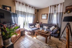 a living room with a couch and a table at La villa d'alyxia in La Bastide-Puylaurent
