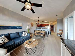 a living room with a blue couch and a ceiling fan at Village Of South Walton #263A in Rosemary Beach