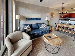 a living room with a blue couch and a table at Village Of South Walton #263A in Rosemary Beach