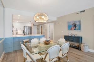 a kitchen and dining room with a glass table and chairs at Emerald Isle #602 in Pensacola Beach
