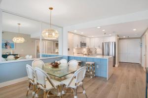 a kitchen and dining room with a glass table and chairs at Emerald Isle #602 in Pensacola Beach