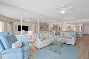 a living room with blue furniture and a mirror at Emerald Isle #602 in Pensacola Beach