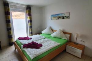 a bedroom with a green and white bed with a window at Strandriff in Borkum