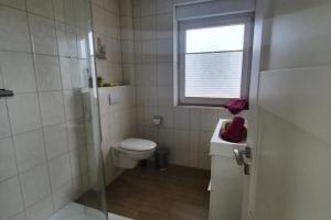 a bathroom with a toilet and a shower and a window at Strandriff in Borkum +8 photos