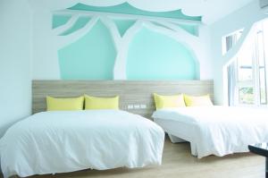 花蓮市的住宿－蘋果樹民宿，卧室内的两张床,配有木壁画