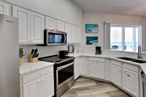 a kitchen with white cabinets and a stove top oven at Crystal View #303 in Destin