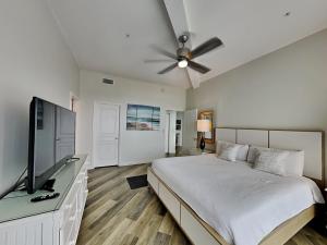 a bedroom with a bed and a flat screen tv at Crystal View #303 in Destin +19 photos