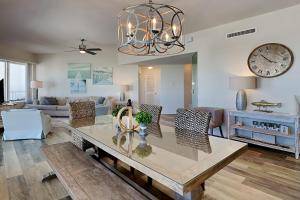 a living room with a table and a clock on the wall at Crystal View #303 in Destin