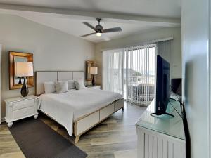 a bedroom with a bed and a flat screen tv at Crystal View #303 in Destin