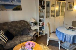 a living room with a couch and a table at Ferienwohnung 2 Gemutlich & komfortabel im Erdgeschoss in Borkum