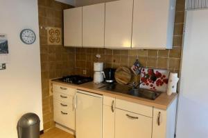 a kitchen with white cabinets and a sink at Ferienwohnung 2 Gemutlich & komfortabel im Erdgeschoss in Borkum
