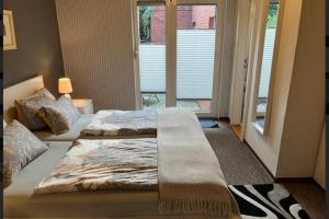 a bed with a blanket on it in a bedroom at Ferienwohnung 2 Gemutlich & komfortabel im Erdgeschoss in Borkum +2 photos