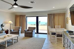 a living room with a table and chairs at Aegean #332 in Destin