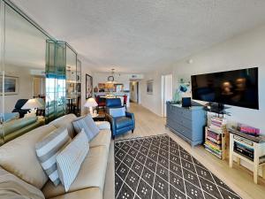 a living room with a couch and a tv at Ocean Breeze East #303 in Perdido Key