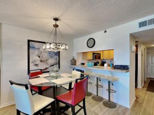 a dining room and kitchen with a table and chairs at Ocean Breeze East #303 in Perdido Key