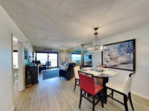 a dining room and living room with a table and chairs at Ocean Breeze East #303 in Perdido Key