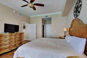 a bedroom with a bed and a flat screen tv at Beach Club #1804C in Pensacola Beach +8 photos