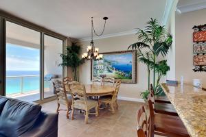 a dining room with a table and chairs and the ocean at Beach Club #1804C in Pensacola Beach