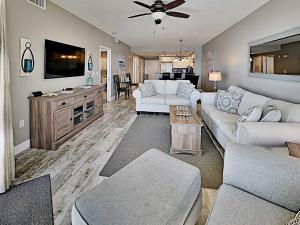 a living room with a white couch and a tv at Emerald Isle #405 in Pensacola Beach