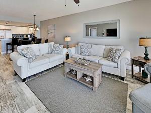 a living room with two white couches and a table at Emerald Isle #405 in Pensacola Beach