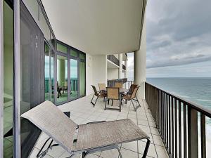 a balcony with chairs and a table and the ocean at Phoenix West II #2109 in Orange Beach