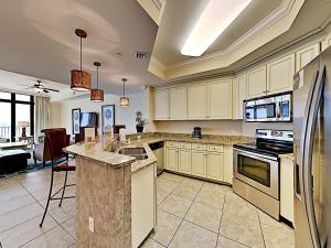 a large kitchen with white cabinets and appliances at Phoenix West II #2109 in Orange Beach +39 photos